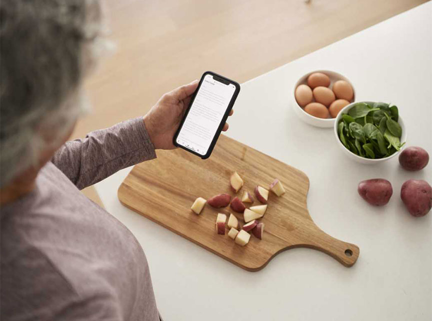 a woman looking at her phone and a table with vegtables
