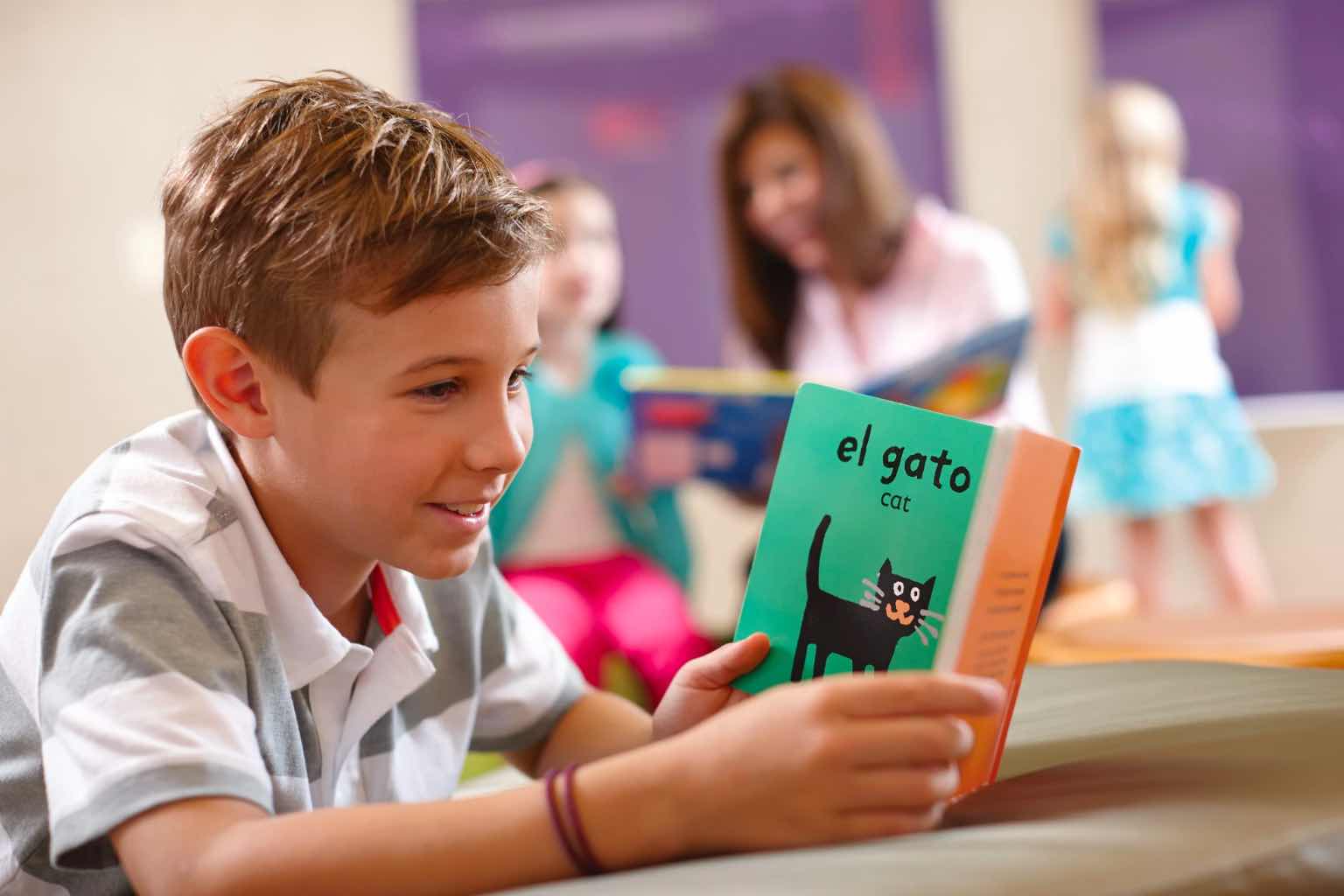 a boy reading a book in Spanish