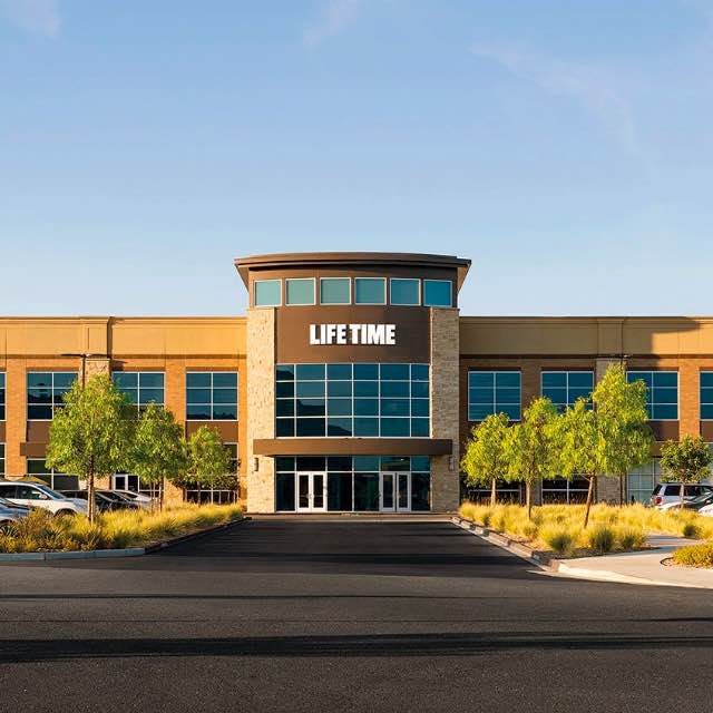 View of Life Time club surrounded by green trees and blue sky