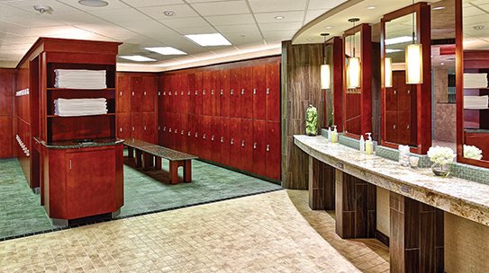 The interior of the Life Time locker rooms with cherry wood lockers and a counter with mirrors