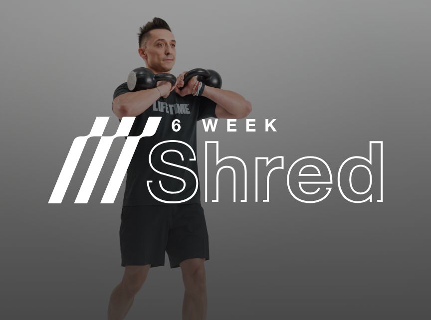 a man in a black life time shirt holding dumbbells up to chests