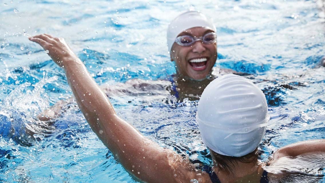two kids swimming together in a pool