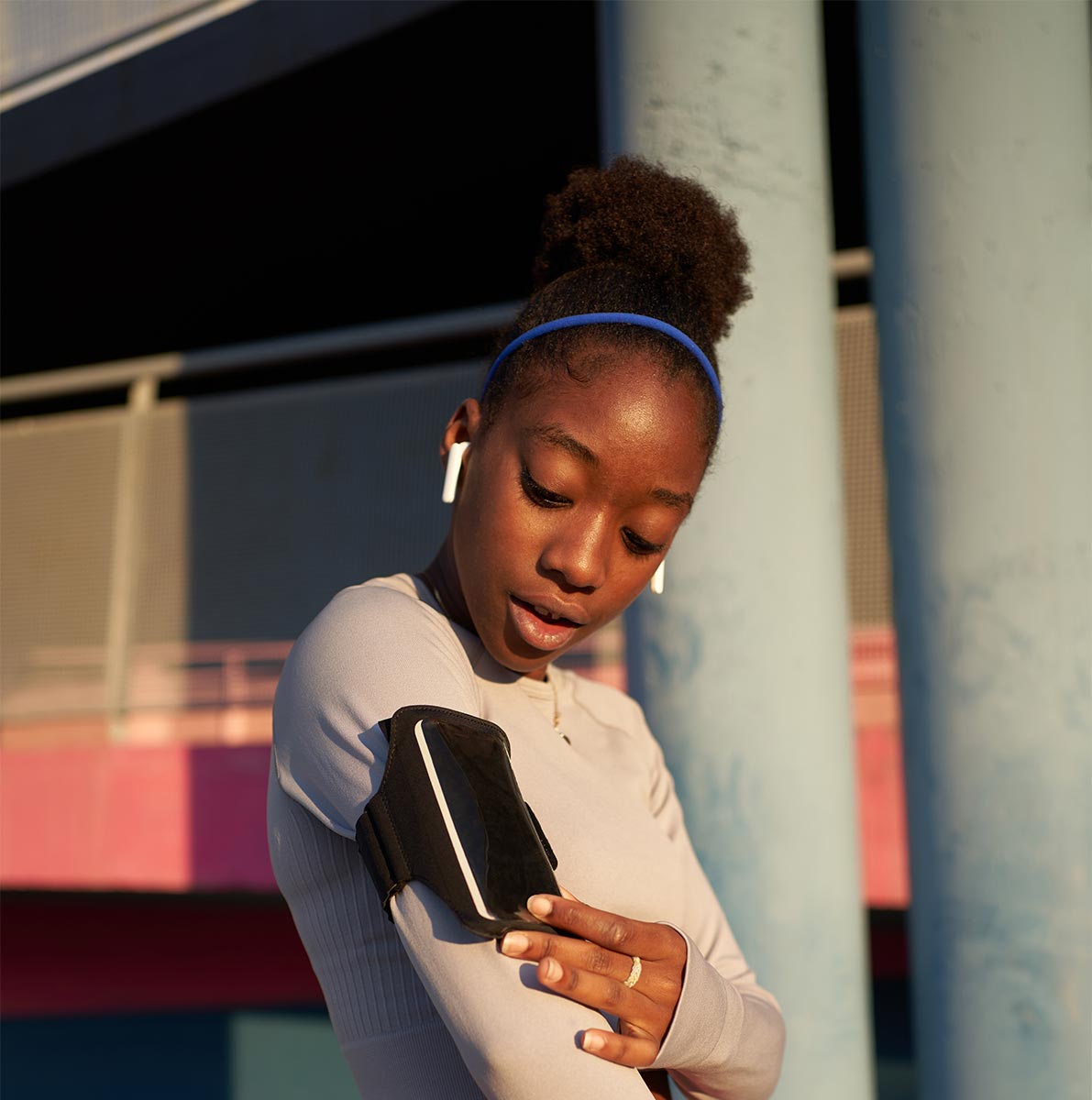 a woman gets ready for a run with a phone attached to her arm