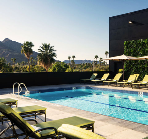 outdoor pool with green lounge chairs