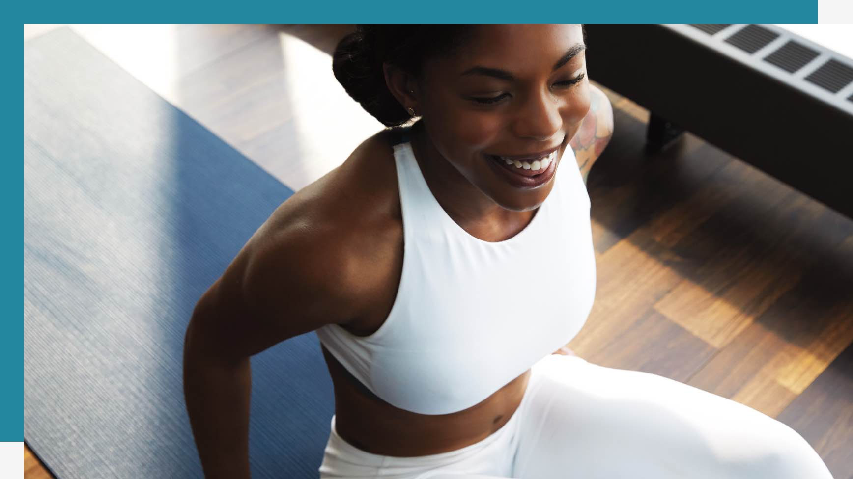 Woman sitting on a yoga mat smiling