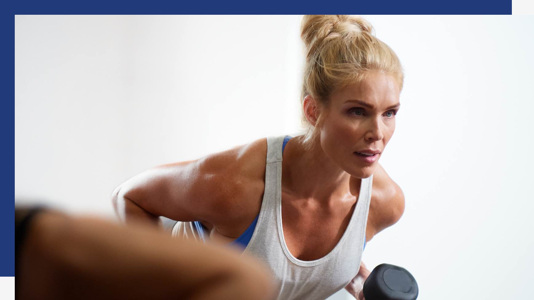 A woman bending over doing an arm row 