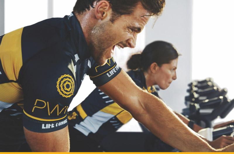 Man and woman riding a bike in Power class