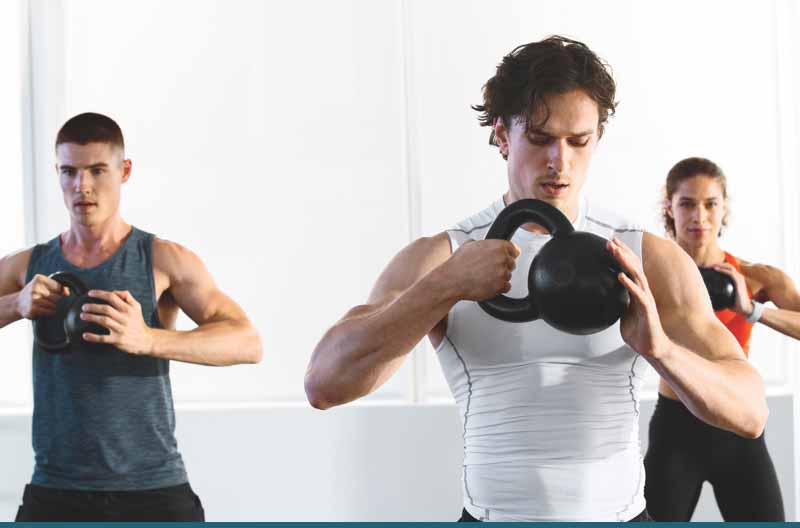 A group of three all lifting a kettlebell